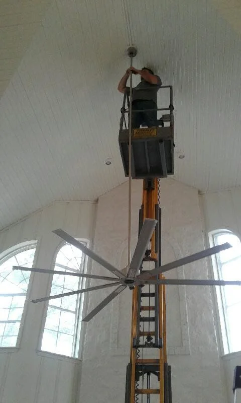 Electrician working on ceiling light and fan